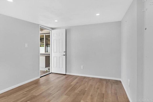 empty room featuring recessed lighting, baseboards, and wood finished floors