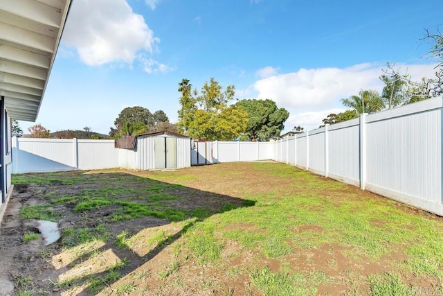 view of yard with a shed, an outdoor structure, and a fenced backyard