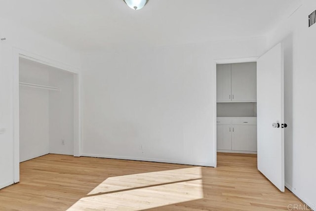 spare room with light wood finished floors and visible vents