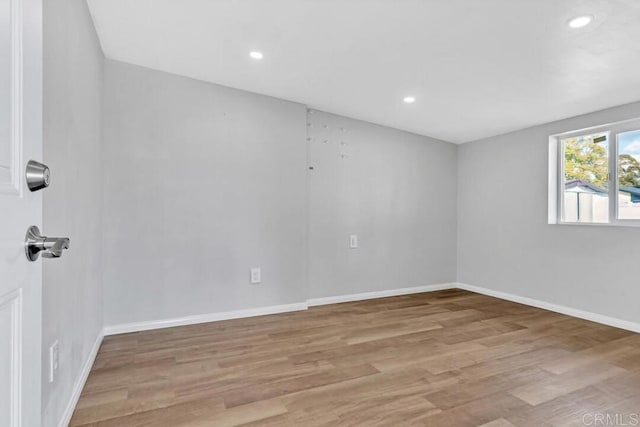 spare room featuring recessed lighting, wood finished floors, and baseboards