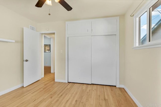 unfurnished bedroom with a closet, visible vents, baseboards, and light wood-style floors