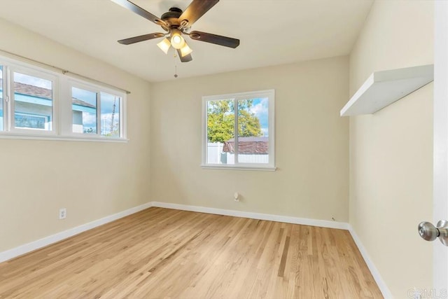 spare room with ceiling fan, light wood-type flooring, and baseboards