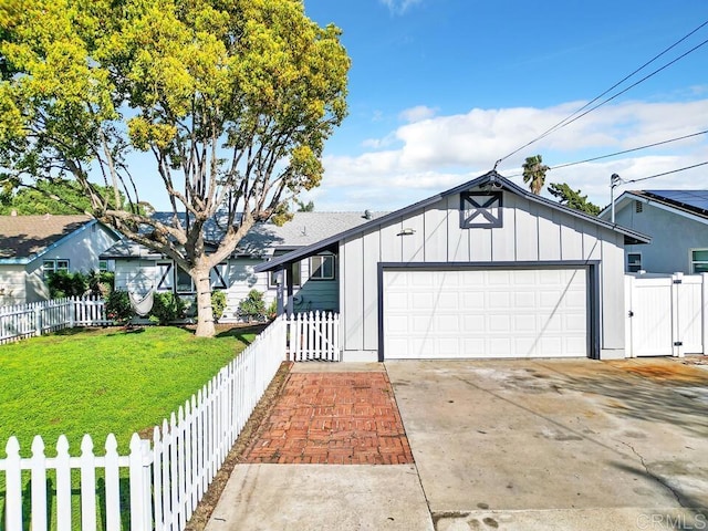 view of front of house featuring a front yard, concrete driveway, fence private yard, and board and batten siding