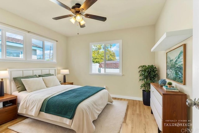 bedroom featuring baseboards, a ceiling fan, and light wood finished floors