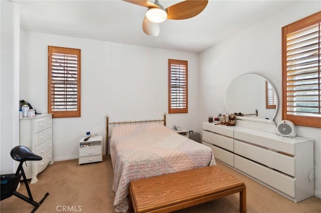 bedroom with light colored carpet, baseboards, and ceiling fan