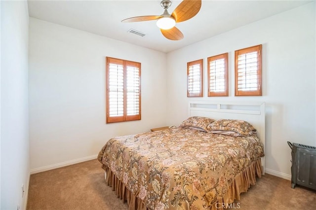 bedroom with ceiling fan, light colored carpet, visible vents, and baseboards