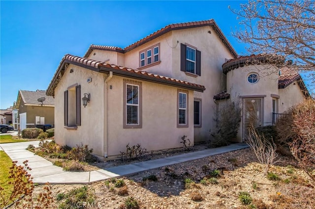 view of property exterior with stucco siding and a tiled roof