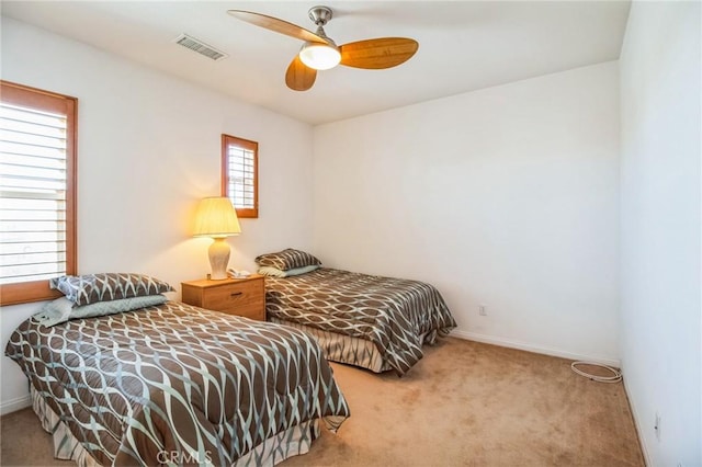 carpeted bedroom featuring visible vents, baseboards, and ceiling fan