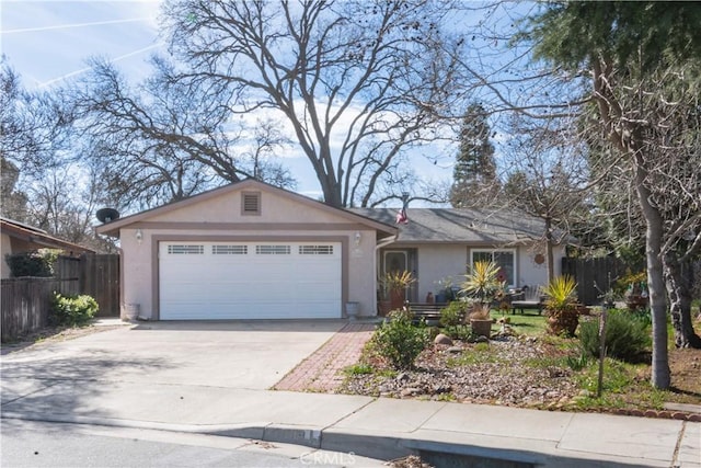 ranch-style house with concrete driveway, an attached garage, fence, and stucco siding