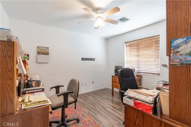 office featuring baseboards, ceiling fan, visible vents, and wood finished floors