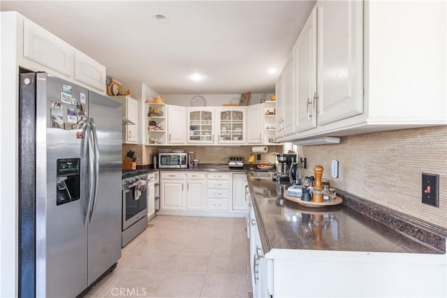 kitchen with open shelves, dark countertops, backsplash, appliances with stainless steel finishes, and light tile patterned flooring