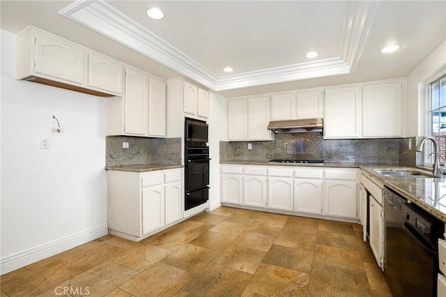 kitchen featuring a tray ceiling, white cabinetry, a sink, under cabinet range hood, and black appliances