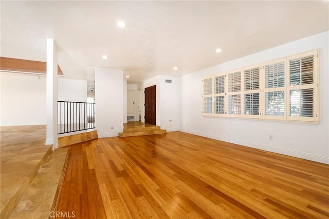 unfurnished room featuring recessed lighting, light wood-type flooring, visible vents, and baseboards