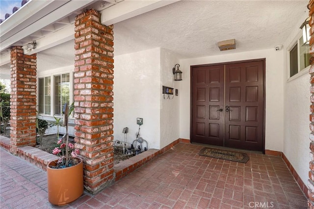 entrance to property with brick siding and stucco siding