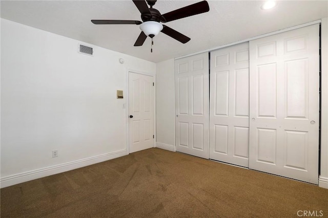 unfurnished bedroom with carpet, a closet, visible vents, ceiling fan, and baseboards