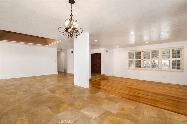 unfurnished living room featuring recessed lighting, a textured ceiling, a chandelier, light wood-type flooring, and baseboards