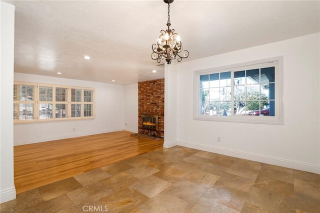 unfurnished living room featuring a fireplace, recessed lighting, light wood-style flooring, a chandelier, and baseboards