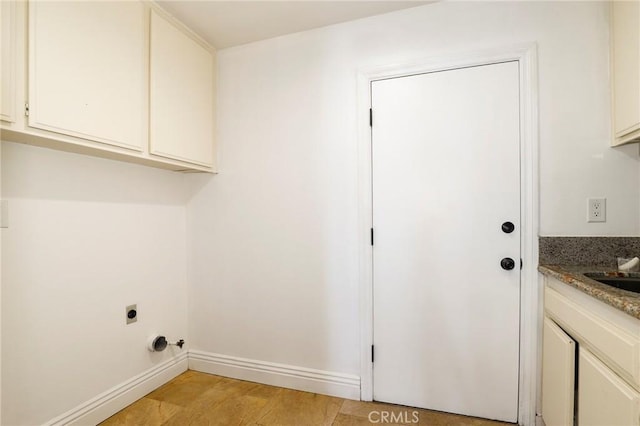 laundry area featuring baseboards, light wood-style flooring, cabinet space, and electric dryer hookup