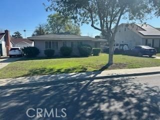 ranch-style home featuring driveway and a front lawn