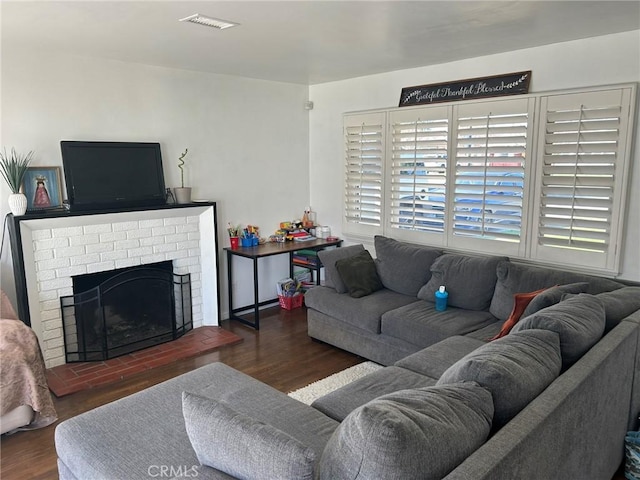 living area featuring a fireplace, visible vents, and wood finished floors