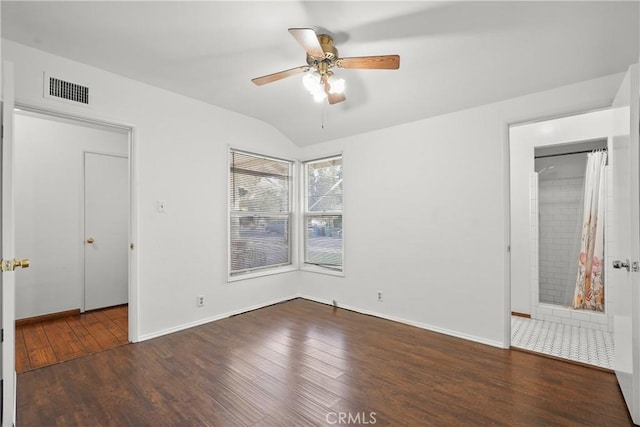 unfurnished bedroom with lofted ceiling, visible vents, hardwood / wood-style floors, ceiling fan, and baseboards