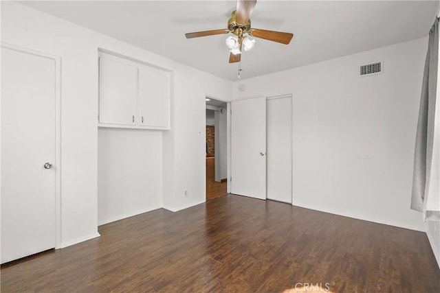 unfurnished bedroom with ceiling fan, wood finished floors, visible vents, and baseboards