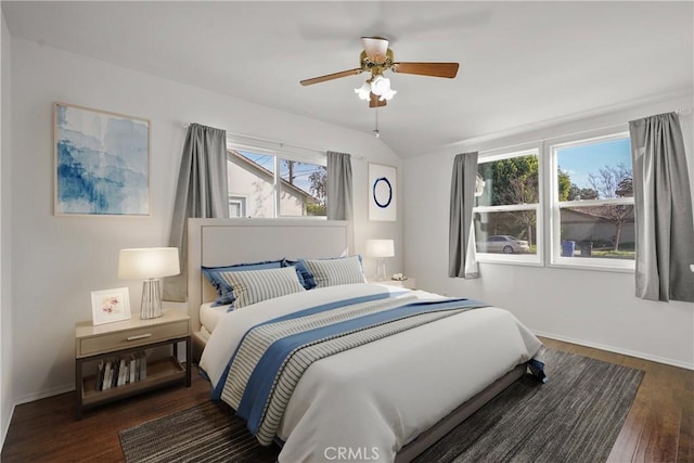 bedroom with a ceiling fan, vaulted ceiling, baseboards, and wood finished floors