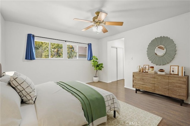 bedroom featuring ceiling fan, a closet, and wood finished floors