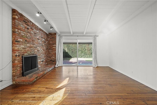 unfurnished living room with hardwood / wood-style floors, a fireplace, and beam ceiling