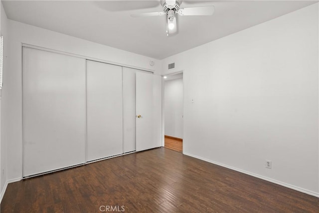 unfurnished bedroom with baseboards, visible vents, a ceiling fan, wood finished floors, and a closet