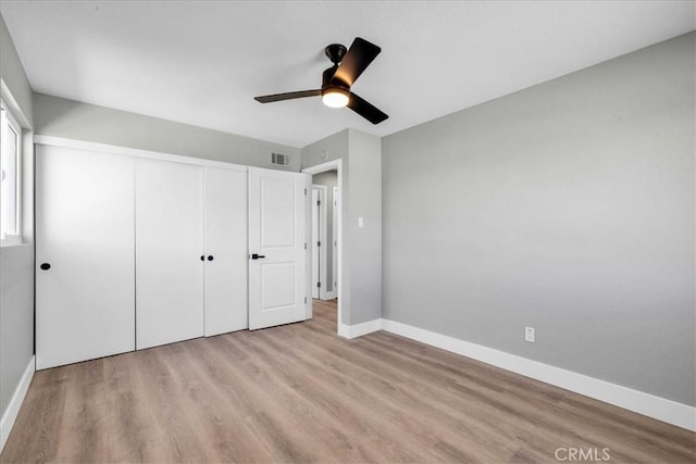 unfurnished bedroom featuring visible vents, baseboards, a ceiling fan, light wood-style floors, and a closet