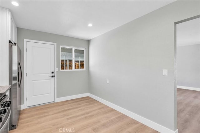 spare room with light wood finished floors, baseboards, and recessed lighting