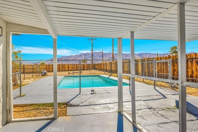 view of pool featuring a patio area, a fenced backyard, a mountain view, and a fenced in pool