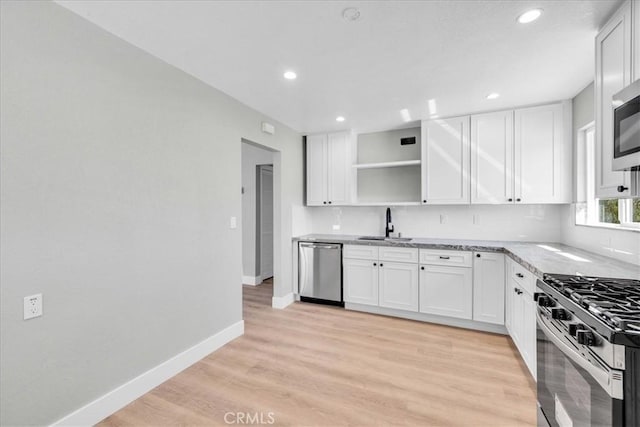 kitchen with baseboards, white cabinets, appliances with stainless steel finishes, light wood-style floors, and open shelves