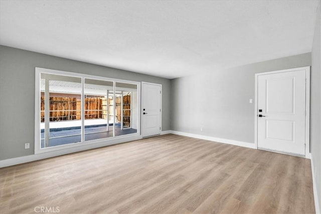 unfurnished room featuring wood finished floors and baseboards