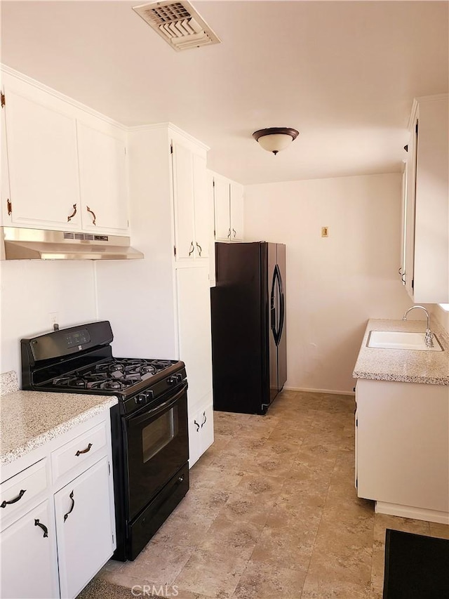 kitchen featuring visible vents, black gas stove, a sink, under cabinet range hood, and fridge with ice dispenser