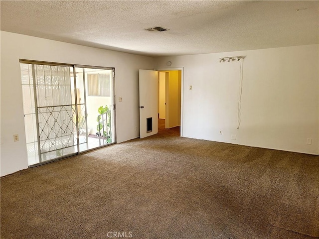 carpeted spare room featuring visible vents and a textured ceiling