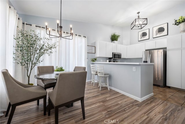 dining area featuring a towering ceiling, a chandelier, and dark wood finished floors