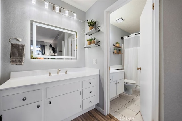 full bathroom with curtained shower, toilet, wood finished floors, visible vents, and vanity