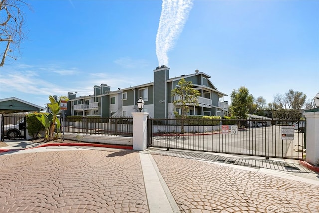 view of front of property featuring a residential view, a gate, and fence