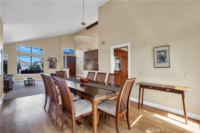 dining room with light wood-type flooring, visible vents, and baseboards