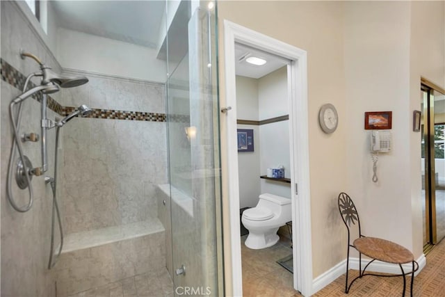 full bath featuring a stall shower, baseboards, tile patterned flooring, and toilet