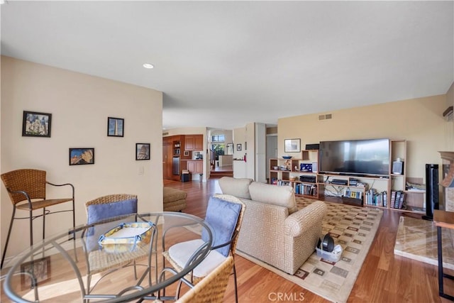 living area with visible vents, a fireplace, and wood finished floors