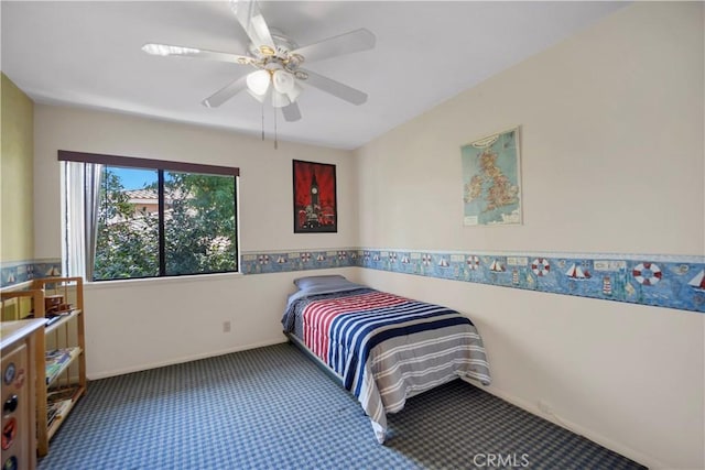 carpeted bedroom with a ceiling fan and baseboards