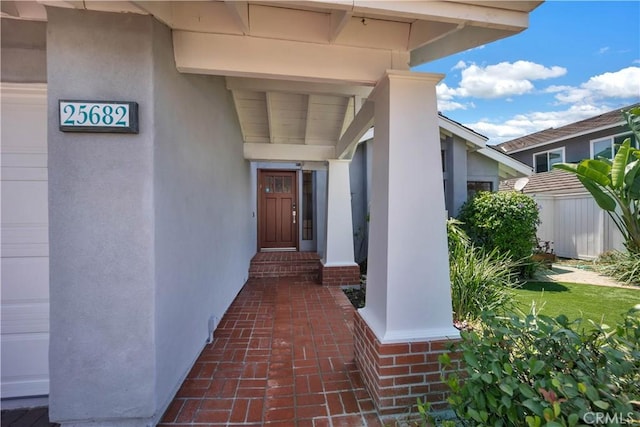 view of exterior entry featuring a garage and stucco siding