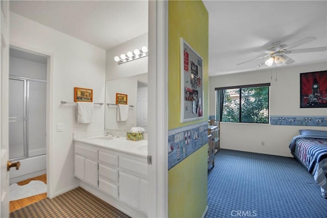 bathroom featuring ceiling fan, a shower with door, a sink, and double vanity