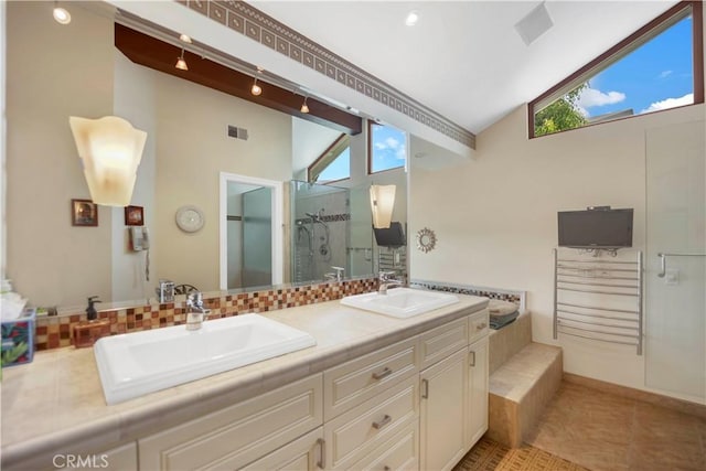 bathroom with lofted ceiling, a shower stall, visible vents, and a sink