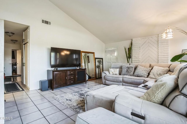living area featuring light tile patterned flooring, visible vents, and high vaulted ceiling