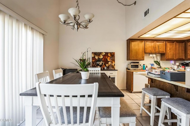 dining space with light tile patterned floors, a notable chandelier, a toaster, and visible vents