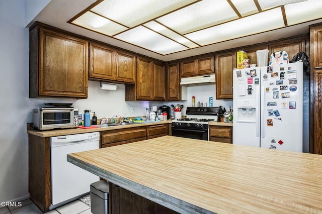 kitchen featuring under cabinet range hood, a toaster, butcher block countertops, white appliances, and a sink